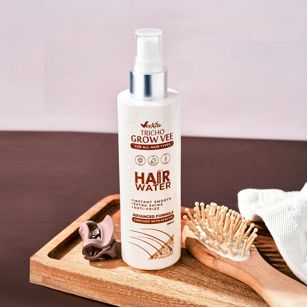 Tricho Grow Vee Hair Water Spray bottle on wooden tray with hairbrush and clip for hydration and care