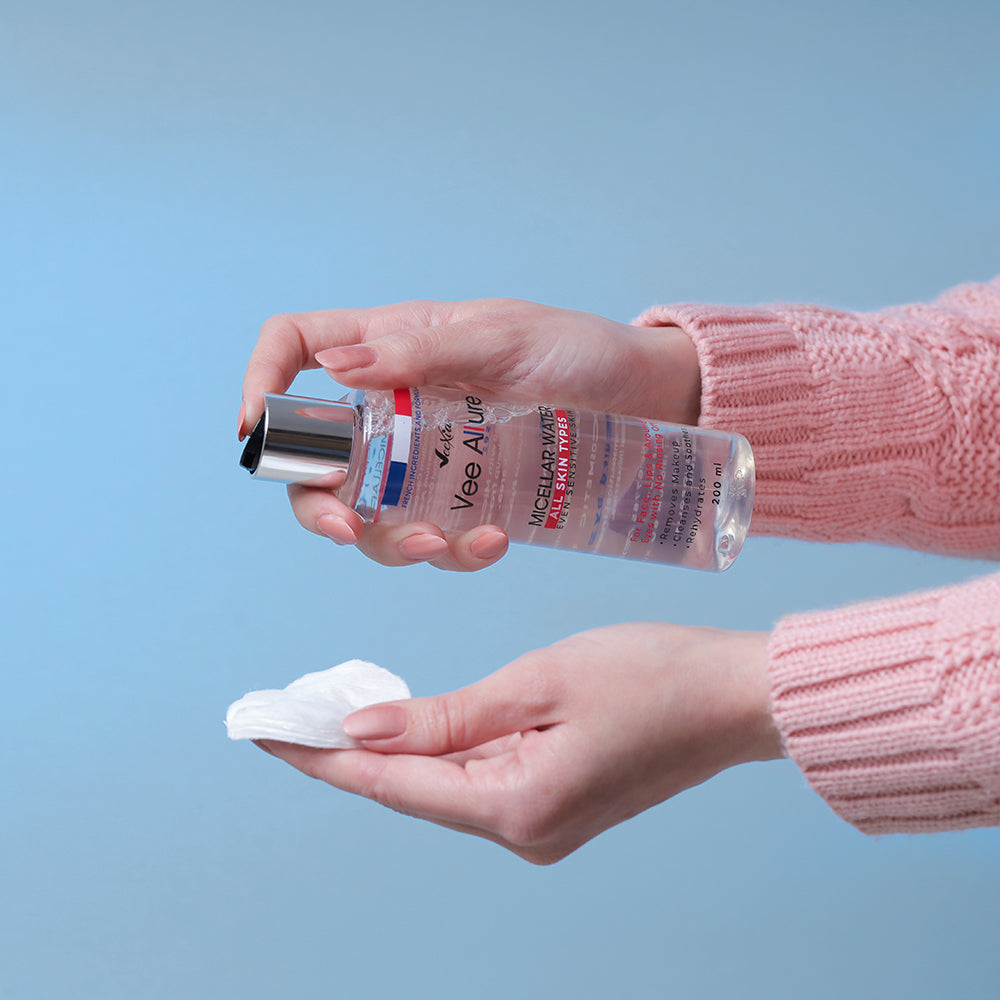 Hand holding Vee Allure Micellar Water bottle and cotton pad for gentle skin cleansing and hydration