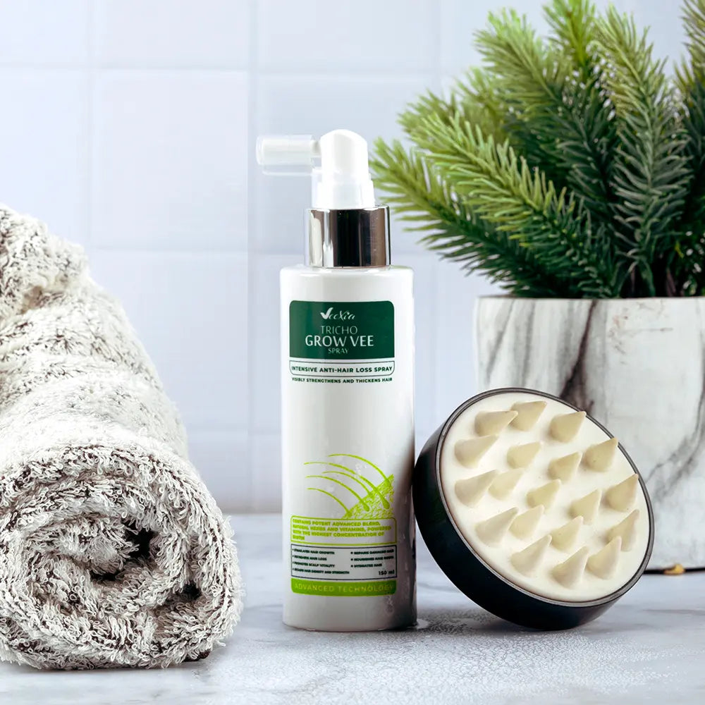 Tricho Grow Vee hair loss spray bottle with scalp massager and towel on bathroom counter