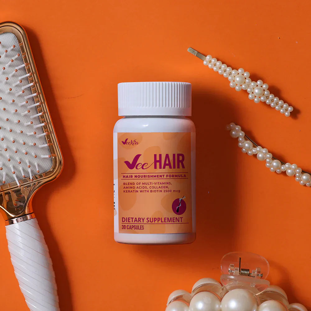Vee Hair capsules dietary supplement for hair loss support with vitamins and minerals on orange background