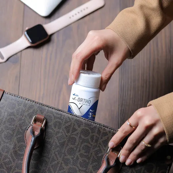Vee Ortho joint health supplement bottle being placed in a handbag by a person