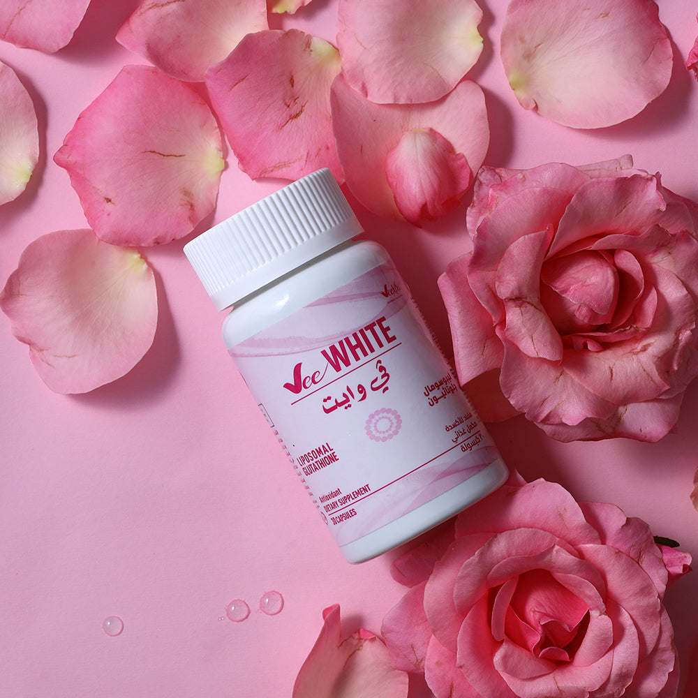 Vee White Liposomal glutathione capsules with Vitamin C for advanced skin whitening and dark spot removal surrounded by pink rose petals